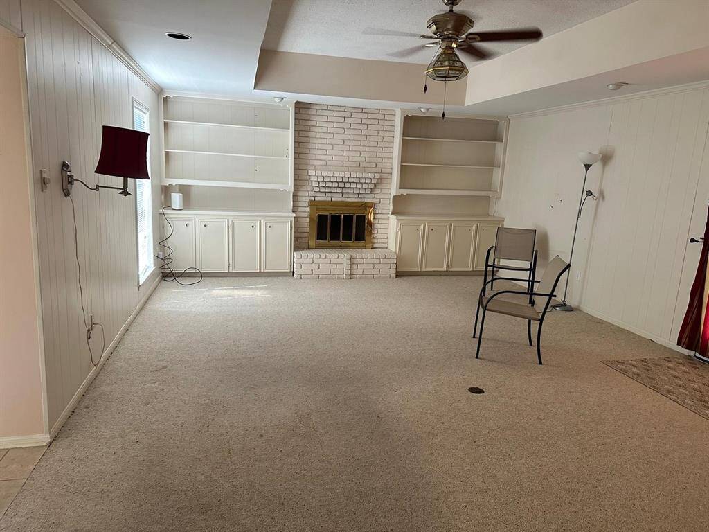 Large living room with fire place and lots of book shelves