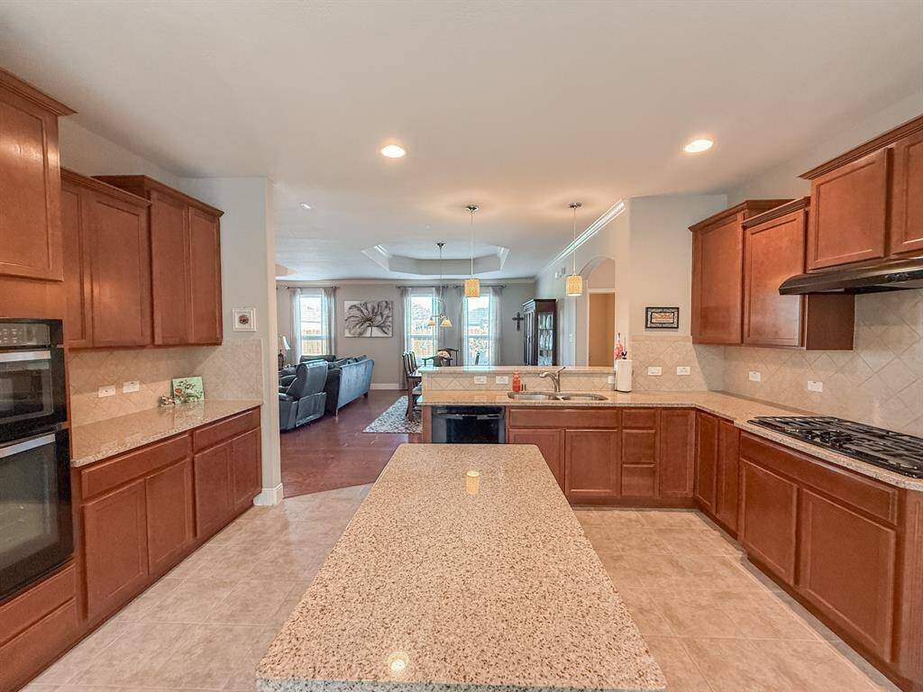 The view from the breakfast room through the kitchen into to dining room and family room.