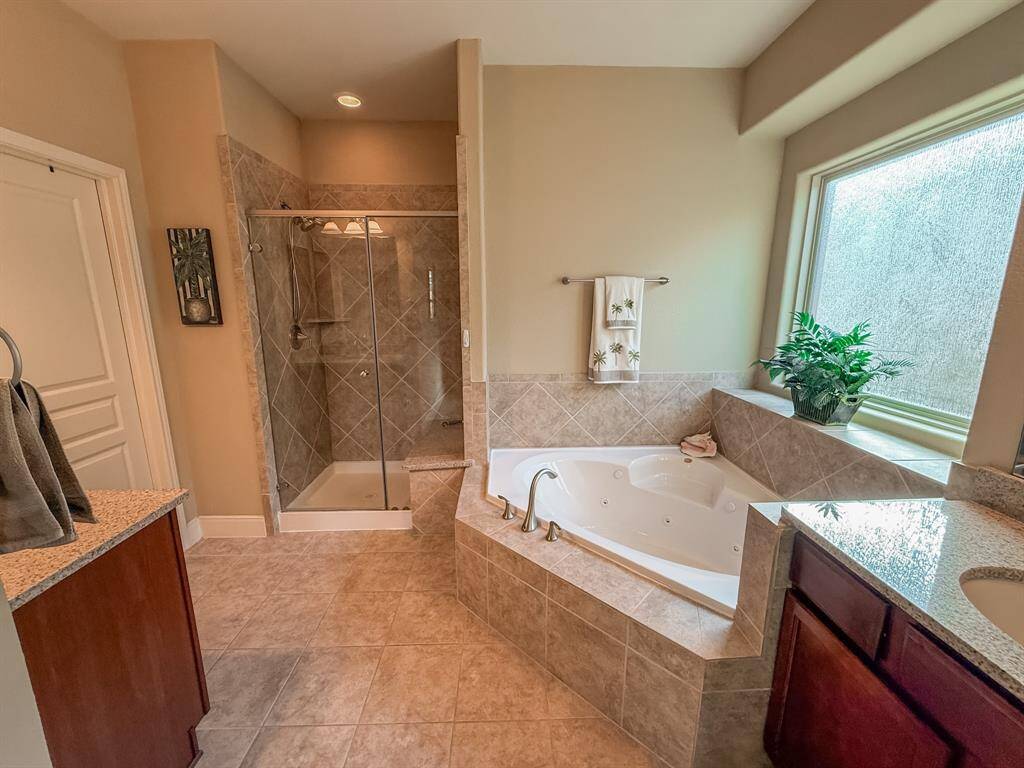 The Primary ensuite bath features a spa tub with seat and a walk in shower with a bench.  Also double vanities.