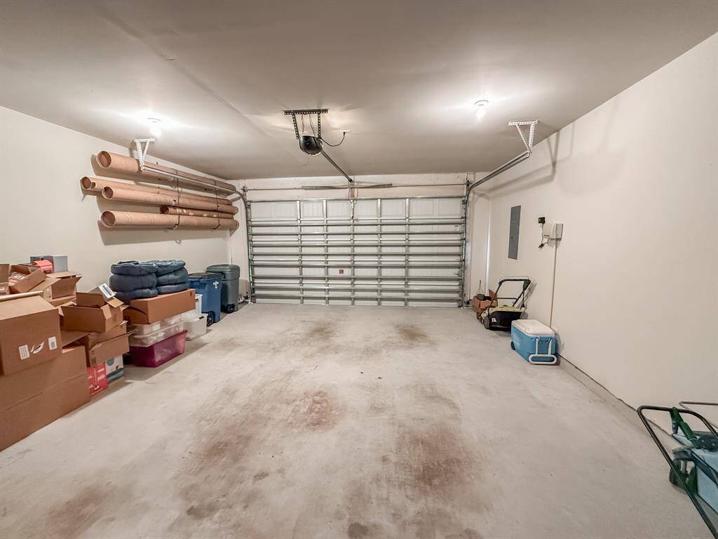 Another view of the garage shows the 5 panel garage door that makes it an additional foot higher than the normal 4 panel doors.  Note the hurricane covers rolled up on the wall to protect the windows in case of a serious storm!