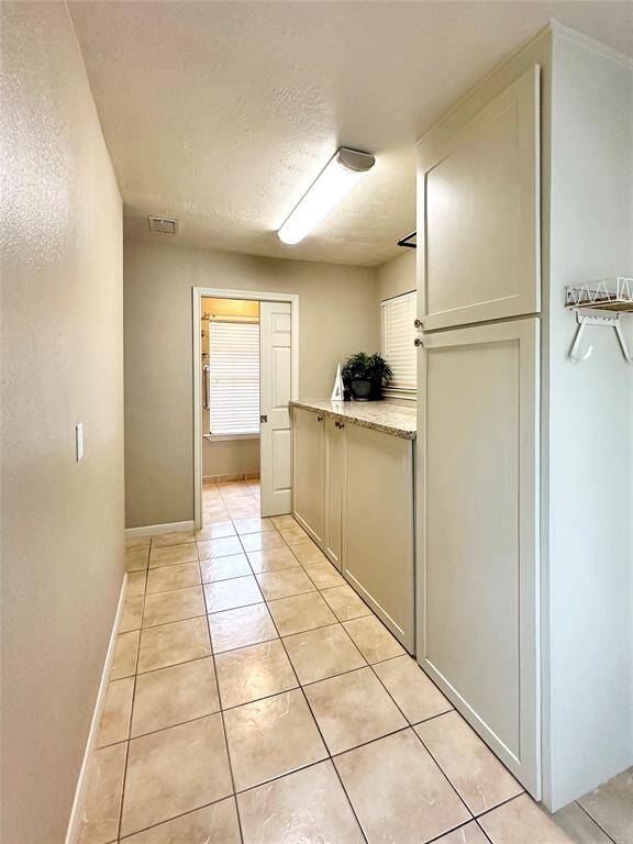 A generously extended laundry room ensures convenience for managing daily household needs. Full restroom is closed off by the pocket door