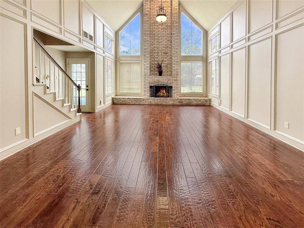 The living room is a statement of warmth and elegance, with rich wood flooring that adds both character and durability.
