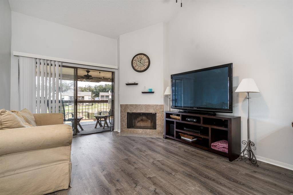 The living room has high ceilings and the patio overlooks the pool and the lake.