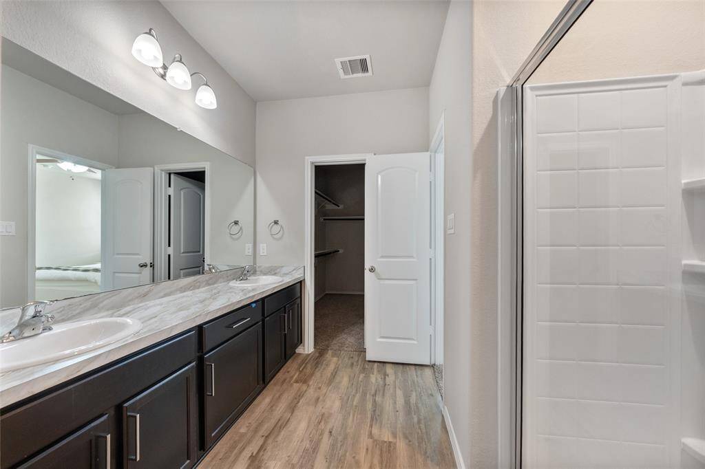 The en suite bathroom offers a spa-like experience with dual sinks