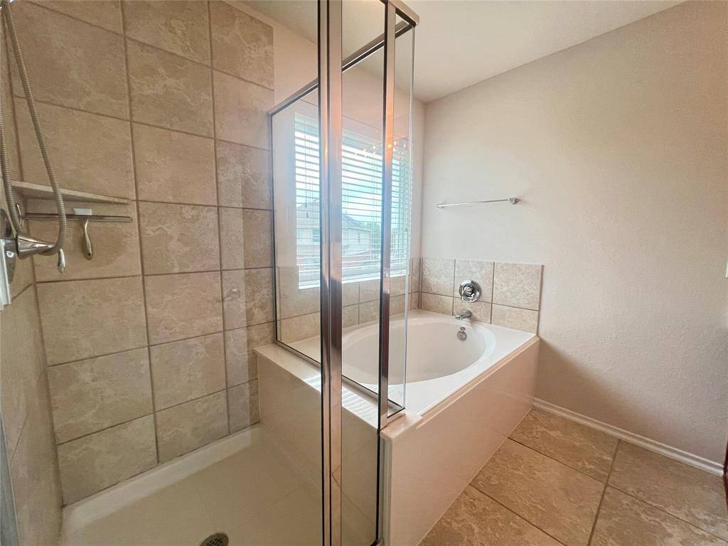 Separate shower and soaking tub in primary bathroom.