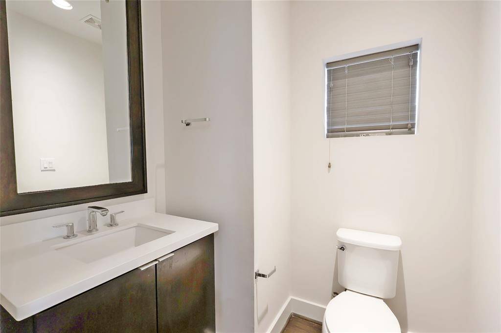 Elegant half bathroom featuring a custom-framed mirror, stylish finishes, and a sleek design—perfect for guests.