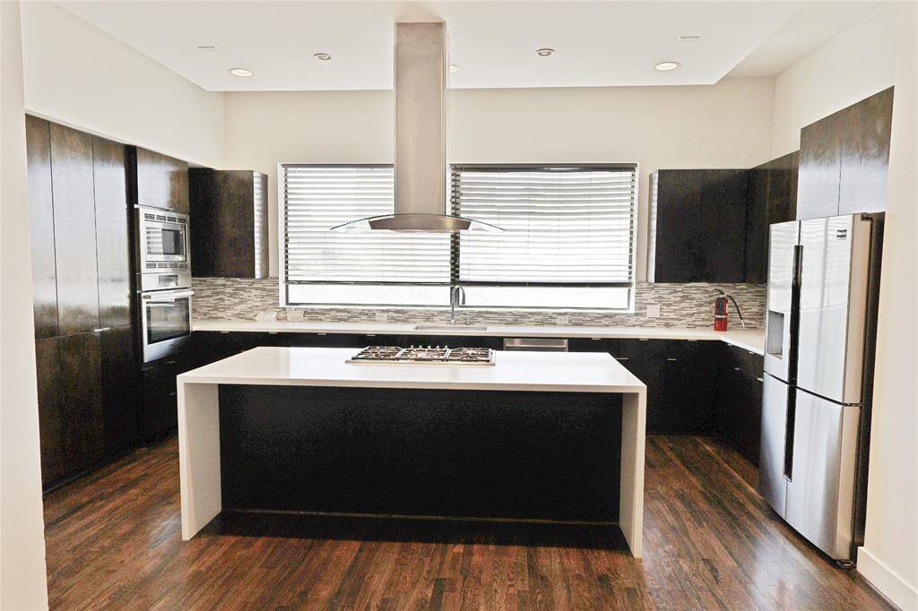 A chef’s dream kitchen! This stunning space features a large island with a cooktop, ample cabinetry for storage, recessed lighting, and sleek stainless steel appliances. Plus, a refrigerator is included for added convenience. Perfect for cooking and entertaining!