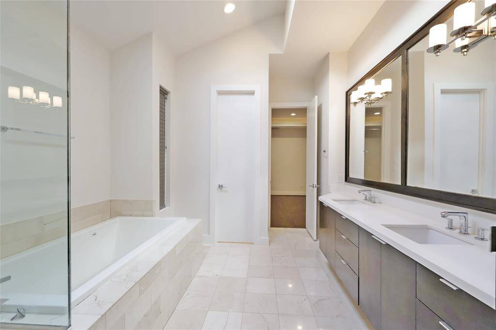 A stunning spa-like bathroom featuring a double vanity, a private water closet.