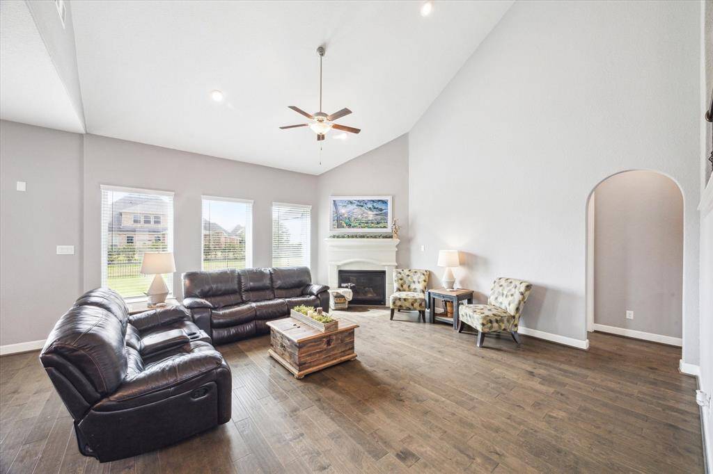 Cozy up by the gas fireplace in a family room featuring soaring two-story ceilings and expansive windows.  All windows in the home are equipped with 2" blinds for privacy.