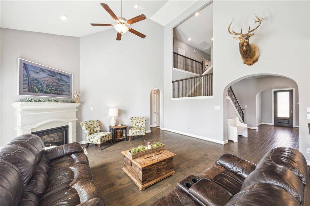 Another view of the family room featuring an open staircase and archways which add architectural interest, enhancing the home's inviting atmosphere.