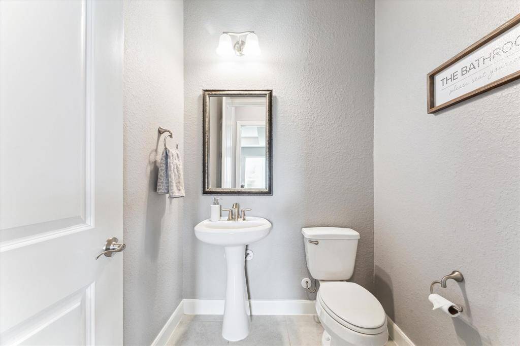 Conveniently located off the family room, this half bath cheerfully features a pedastal sink and framed mirror.