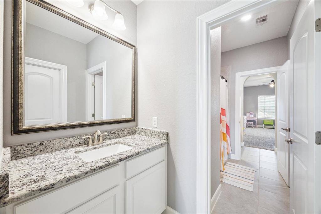 Jack and Jill bath shared between two of the upstairs bedrooms.  Neutral paint, granite countertops and designer mirrors.