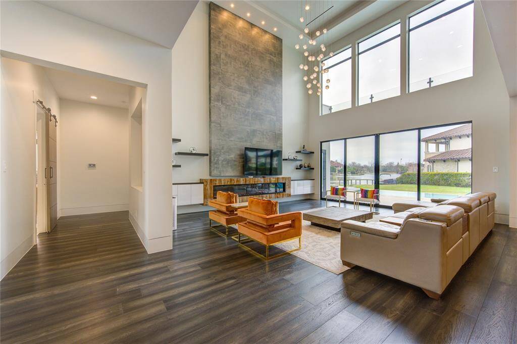 UPGRADED FAMILY ROOM WITH CUSTOM BUILT-INS, 10' ELECTRIC FIREPLACE, CHANDELIER & WESTERN SLIDING DOORS