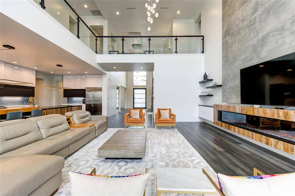 UPGRADED FAMILY ROOM WITH CUSTOM BUILT-INS, 10' ELECTRIC FIREPLACE, CHANDELIER & WESTERN SLIDING DOORS