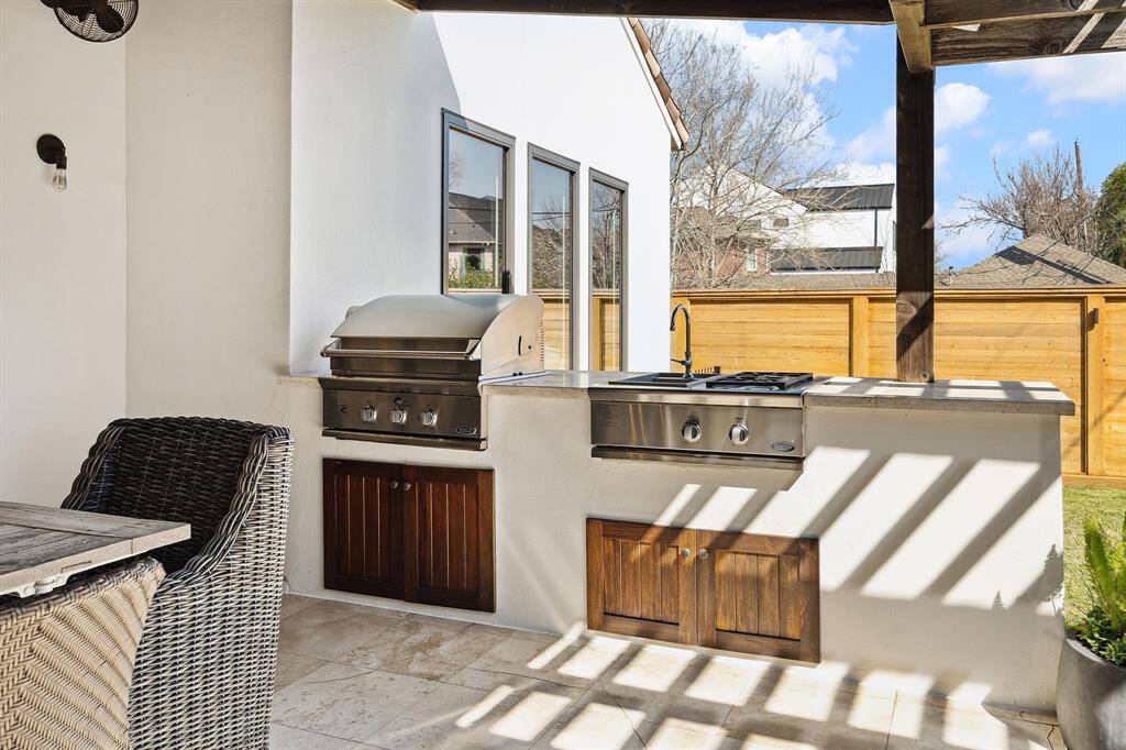 Outdoor kitchen, grille, cooktop and sink.