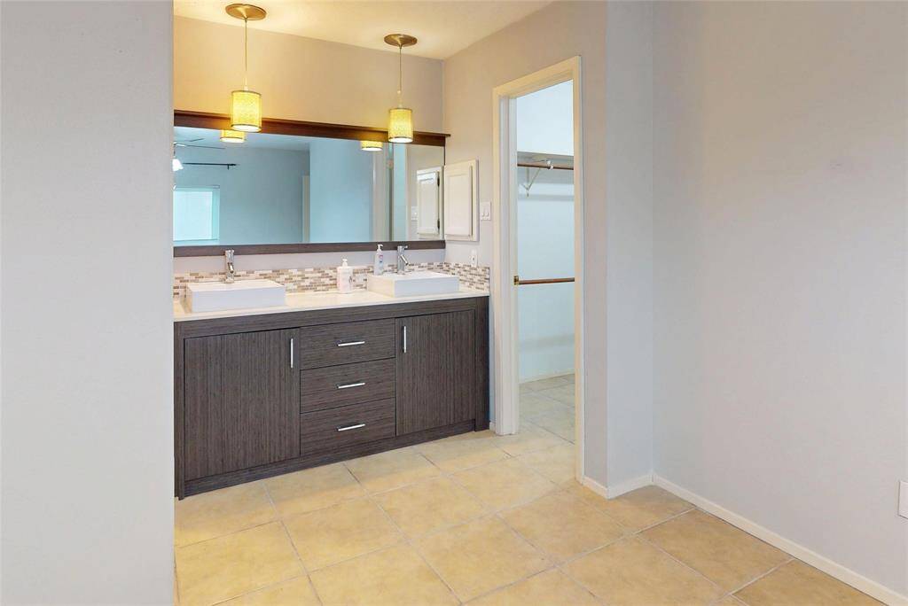 A pretty backsplash and modern sinks grace this lovely and spacious vanity cabinet with 3 working drawers.