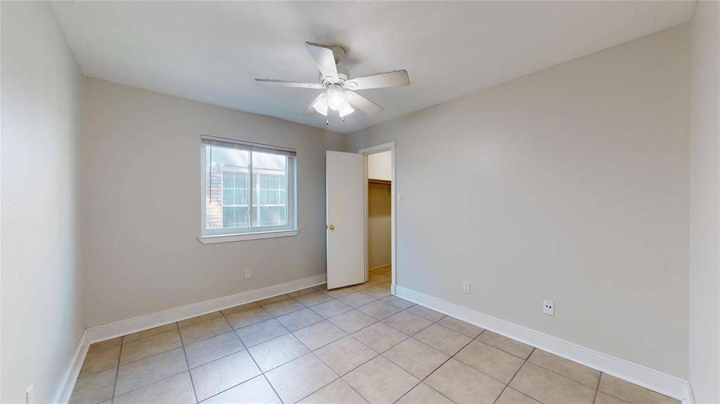 This alternate view of the first secondary bedroom showcases the double-paned windows and tile flooring.