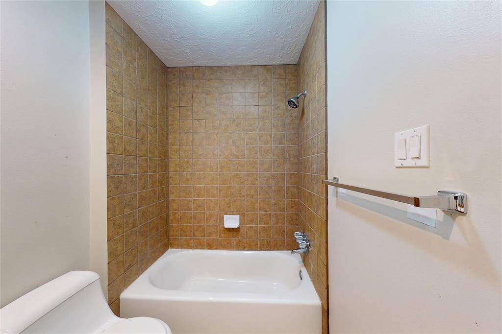 This pretty tub-shower combo, like the primary bath, also has tile completely to the ceiling
