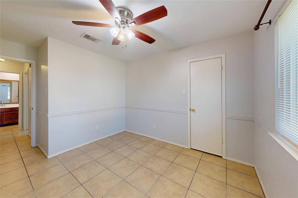 The other secondary bedroom has tiled flooring, a lighted, 5-blade ceiling fan and attractive light-colored  paint.