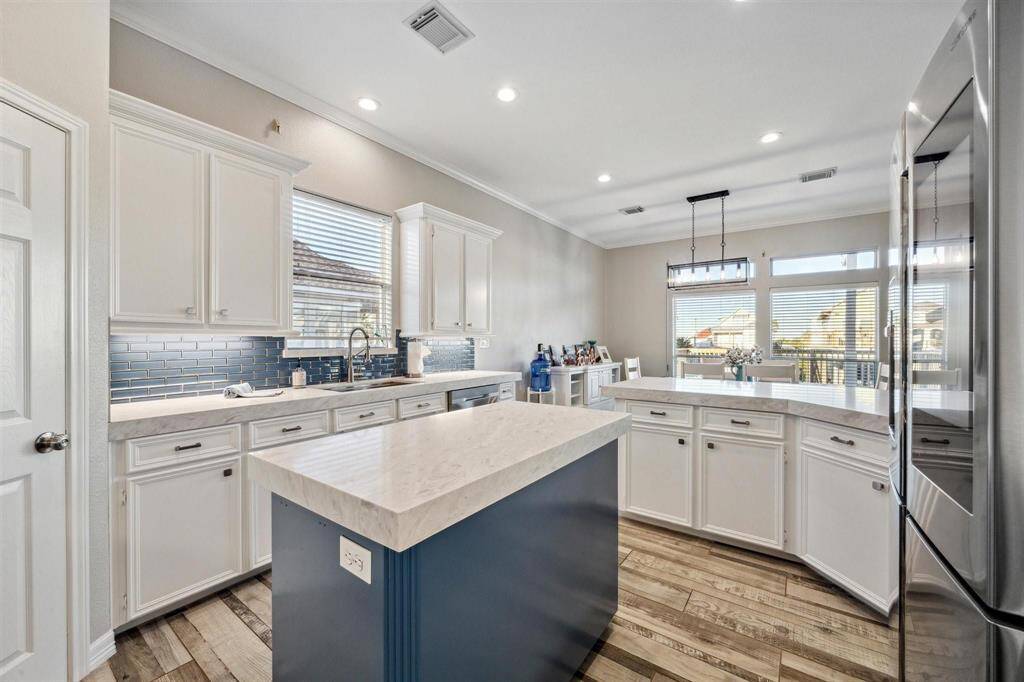 Experience the elegance of a chic blue kitchen island perfectly complementing pristine white cabinetry.
