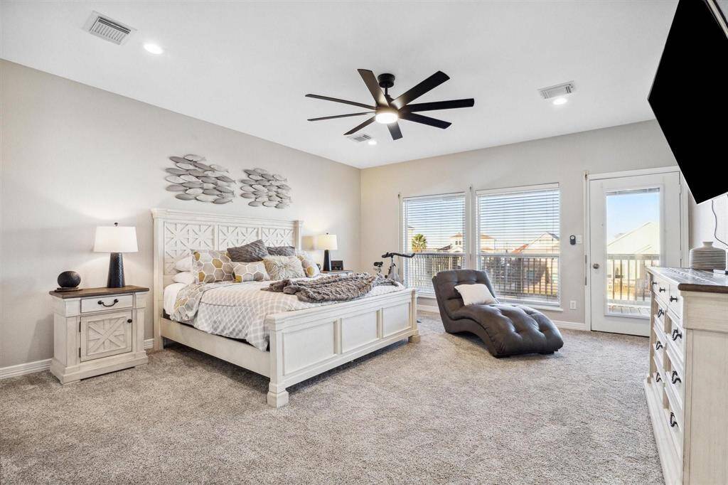 Spacious primary bedroom with a cozy sitting nook and ample windows that bathes the room in sunlight.