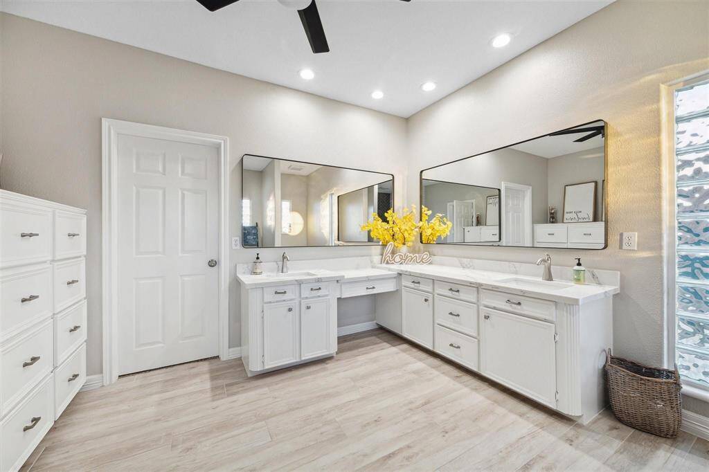 Spacious, modern primary bathroom featuring elegant quartz countertops.