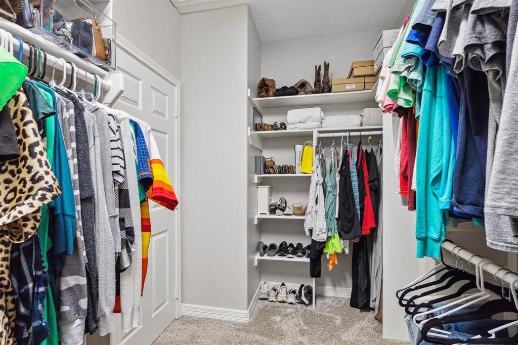 Spacious walk-in closet in the primary suite, offering ample storage with built-in shelving.