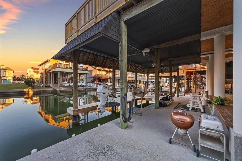 Expansive shaded deck with serene waterfront views, perfect for outdoor living and entertaining.