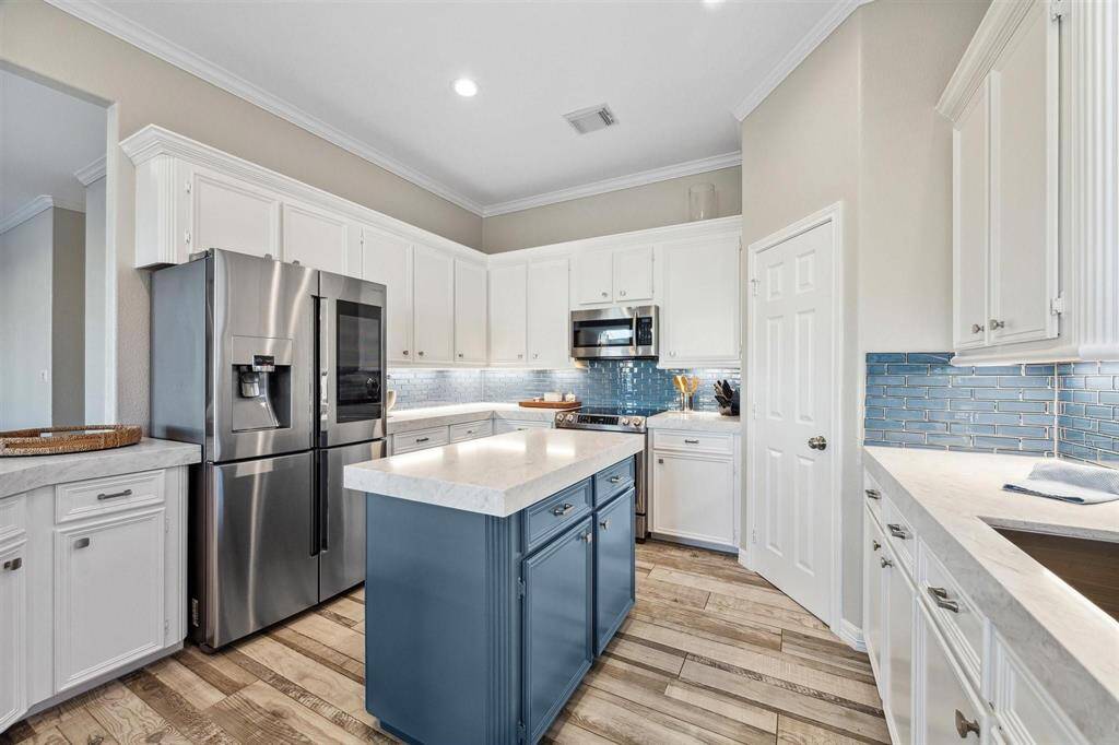 Chick kitchen with modern blue subway tile backsplash.