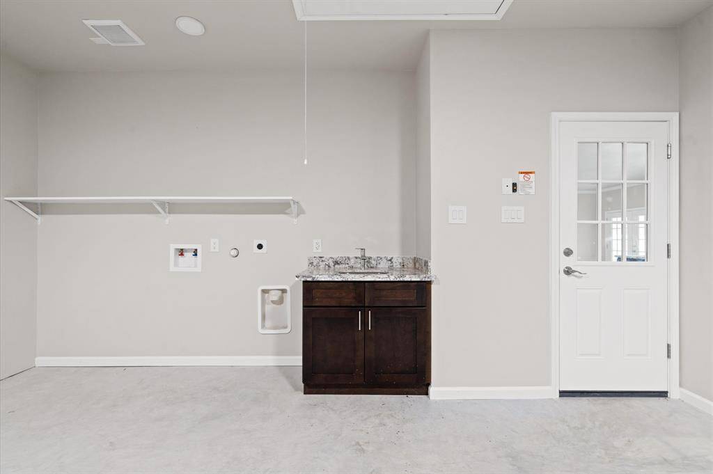 Laundry area with a sink located in the garage.