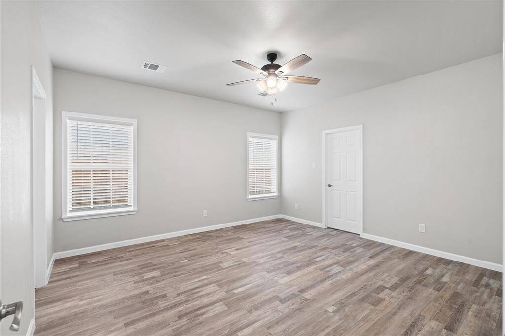 Primary bedroom with a ceiling fan.