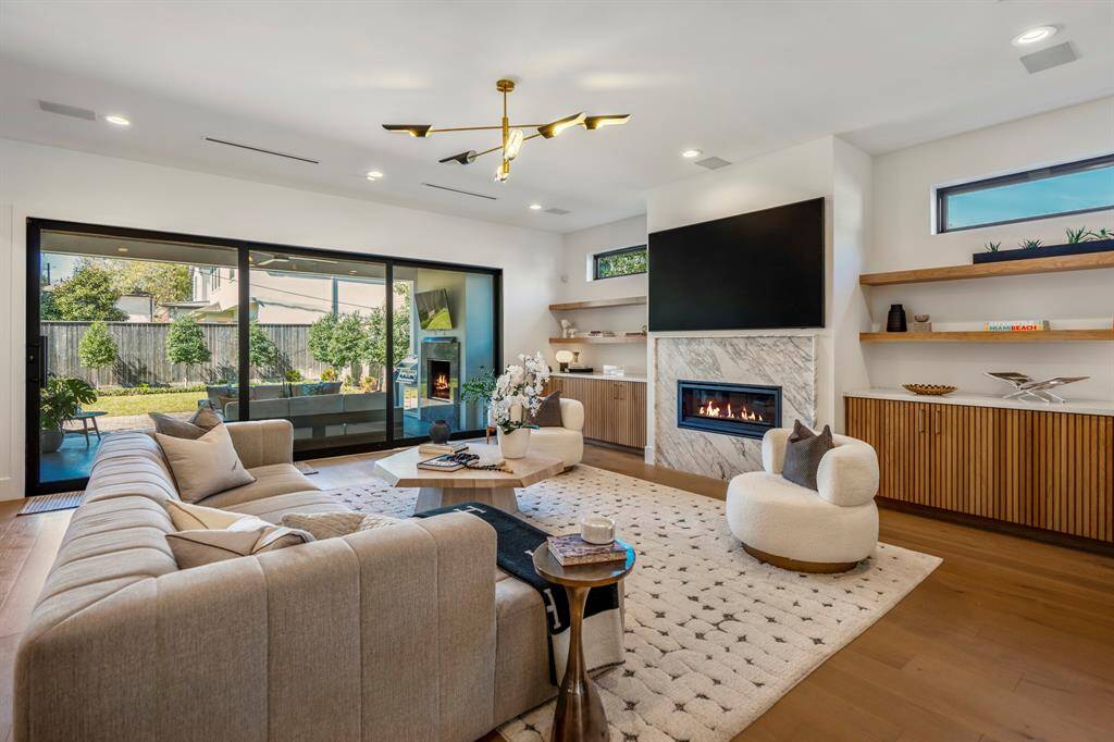 Welcome into your spacious living room. The centerpiece of this home is the Calcatta Cerviole polished marble fireplace. Michelangelo quartz counters. Expansive sliding glass doors invite indoor/outdoor living.