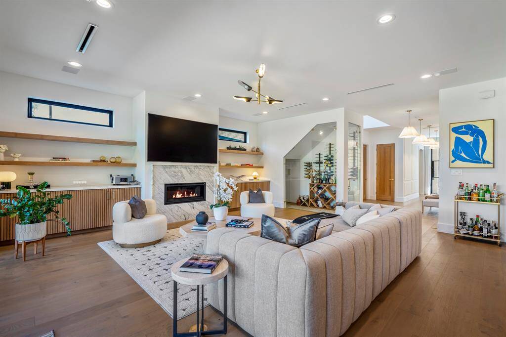 Custom-made white oak slat cabinets flank the fireplace with white oak floating shelves above.