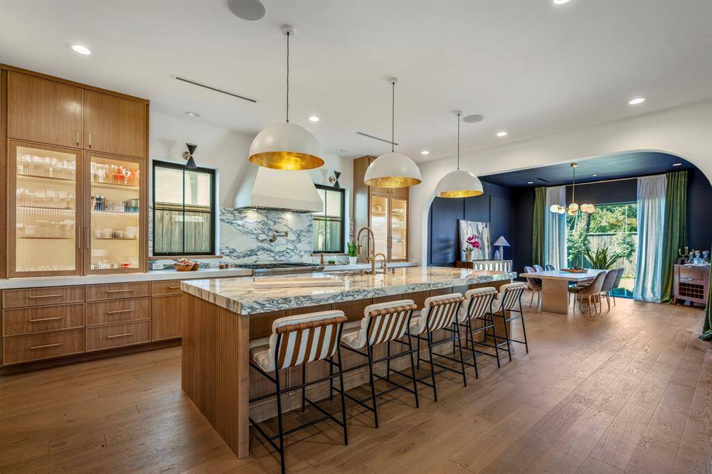 An exquisite three-inch Arabescato Corchia marble island with custom wood work throughout this incredible kitchen.