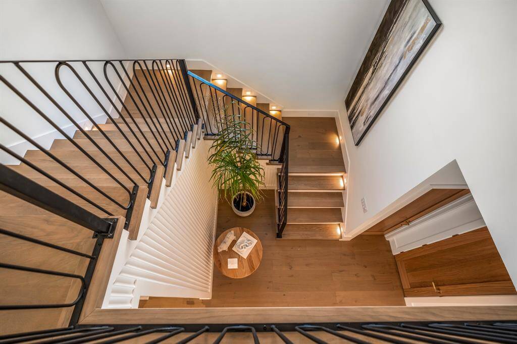 Ascend these stunning stairs adorned with illuminated risers and intricate wrought iron detailing, as we make our way to the top floor of this incredible home.