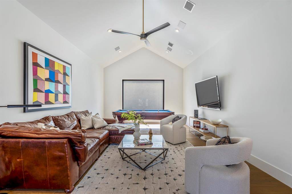 At the top of the stairs, a sprawling game room welcomes you, offering an inviting space for entertainment and relaxation.
