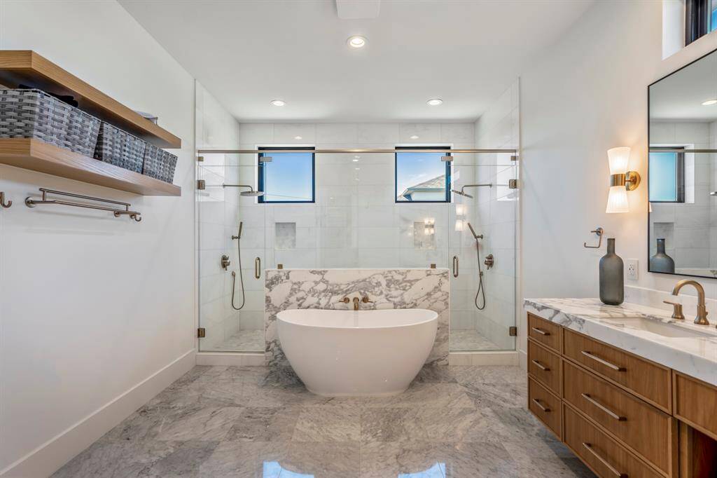 This luxurious walk-in shower is a true spa-like experience, featuring dual entrances for seamless accessibility, twin rainfall shower heads for a lavish experience, and two handheld wands for personalized convenience.