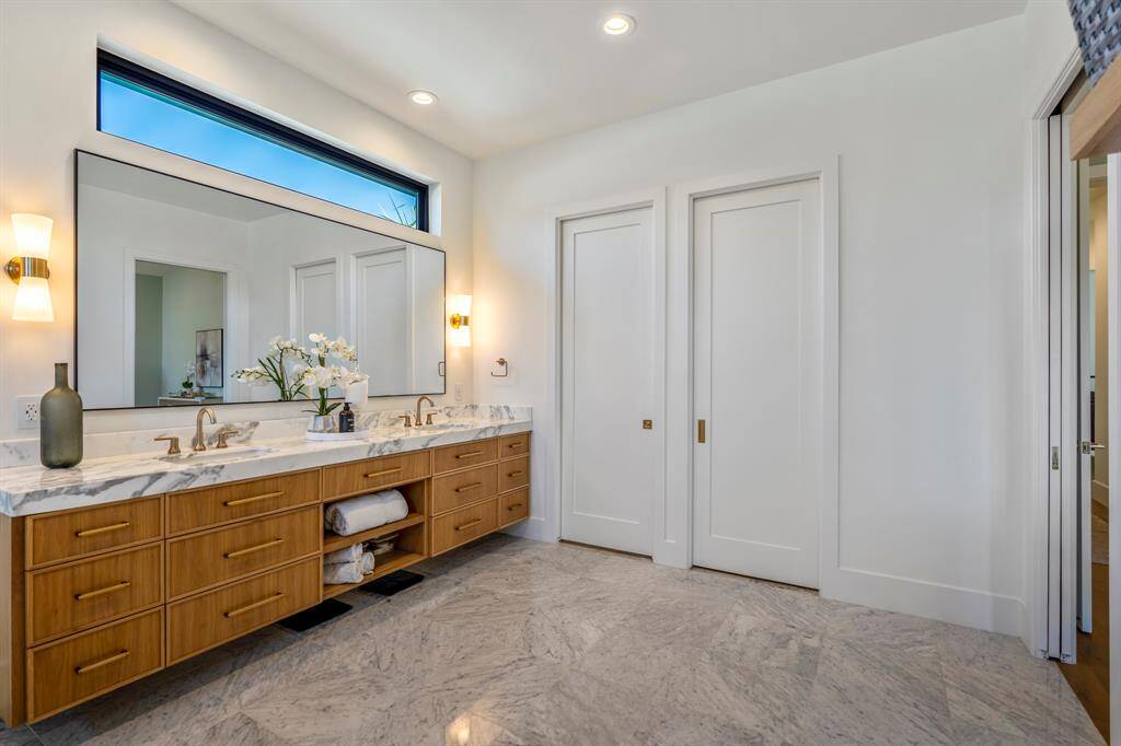 Closed pocket door on the left is the water closet featuring a Moen Bidet. Closed pocket door to the right is an expansive walk-in closet with an island.