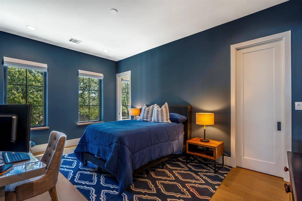 Another secondary en-suite bedroom with a walk-in closet. Windows overlook beautiful front yard trees.