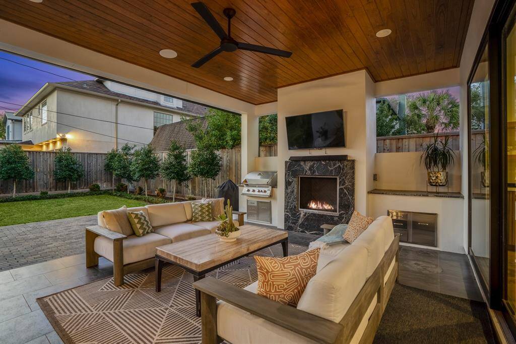 In this dreamy covered lanai: a cozy gas fireplace, outdoor grill, and ample space for outdoor furniture to enjoy beautiful nights with friends and family.