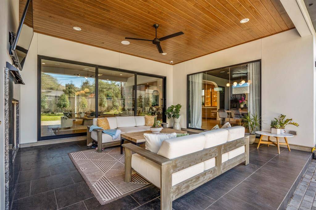 A teak ceiling in this covered lanai lends an air of refined sophistication, enriching this space with warmth and timeless elegance.