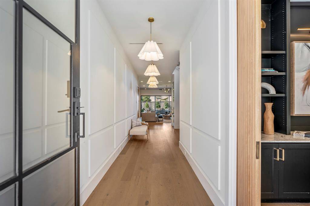 .Just inside the wrought iron front door, engineered white oak floors greet you with custom panels and designer lighting. Sliding fluted wood pocket door to the right leads to a first-floor study/office.