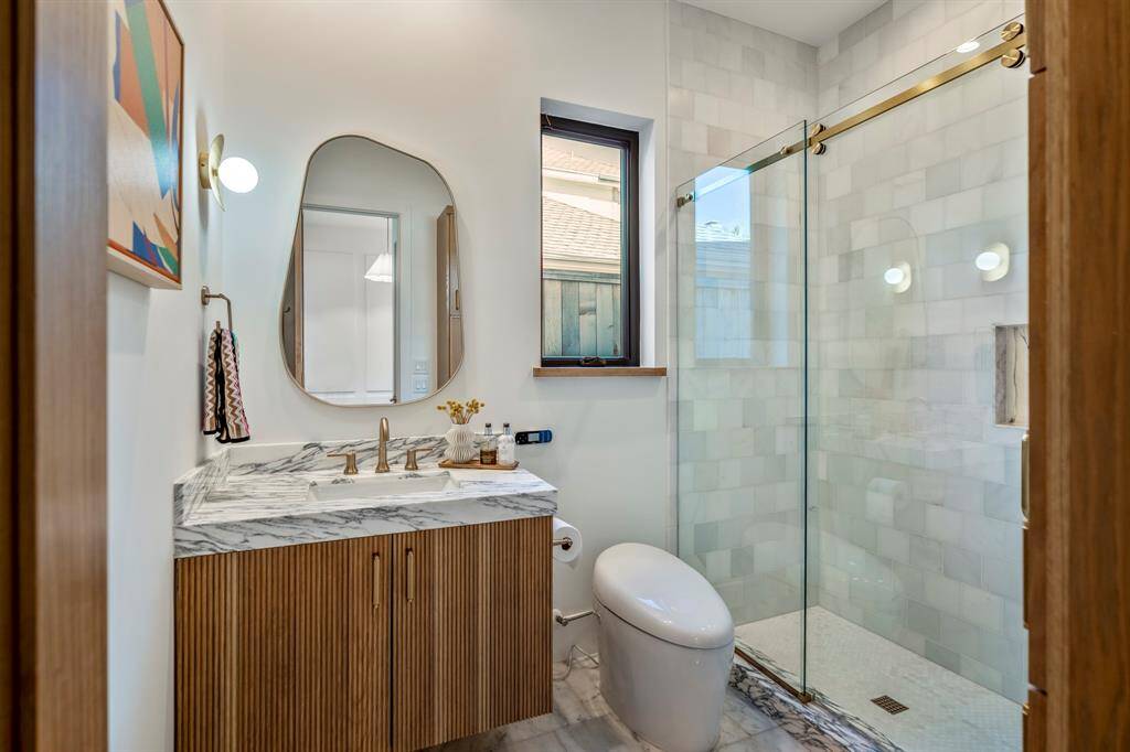 Welcome inside this private retreat with a full stand-up shower. Arabescato Corchia polished marble vanity and a Kohler Bidet.