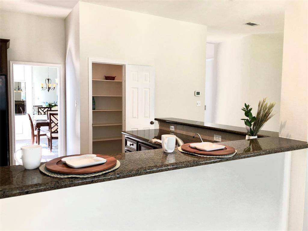 Granite countertops and spacious pantry in kitchen.