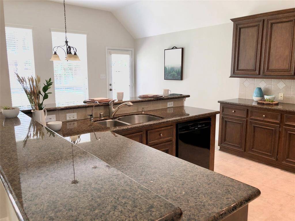 An spacious open kitchen with granite countertops and breakfast bar.