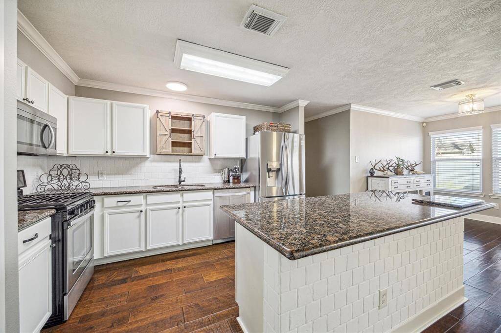 The kitchen boasts polished stainless steel appliances that perfectly complement the modern design. With top-of-the-line features, this space is both functional and visually stunning.