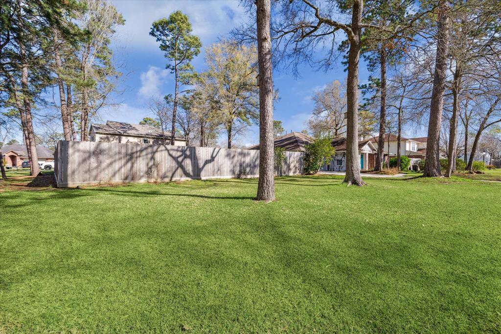 The large lawn area, framed by mature trees, offers limitless possibilities for outdoor enjoyment. Whether you envision a garden, a play area, or simply a peaceful place to relax, this space has it all.