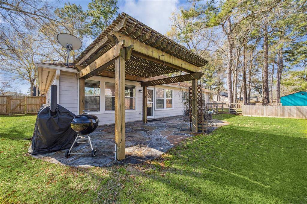 This inviting stamped stone patio is enhanced by a graceful pergola, creating an ideal setting for outdoor entertaining.