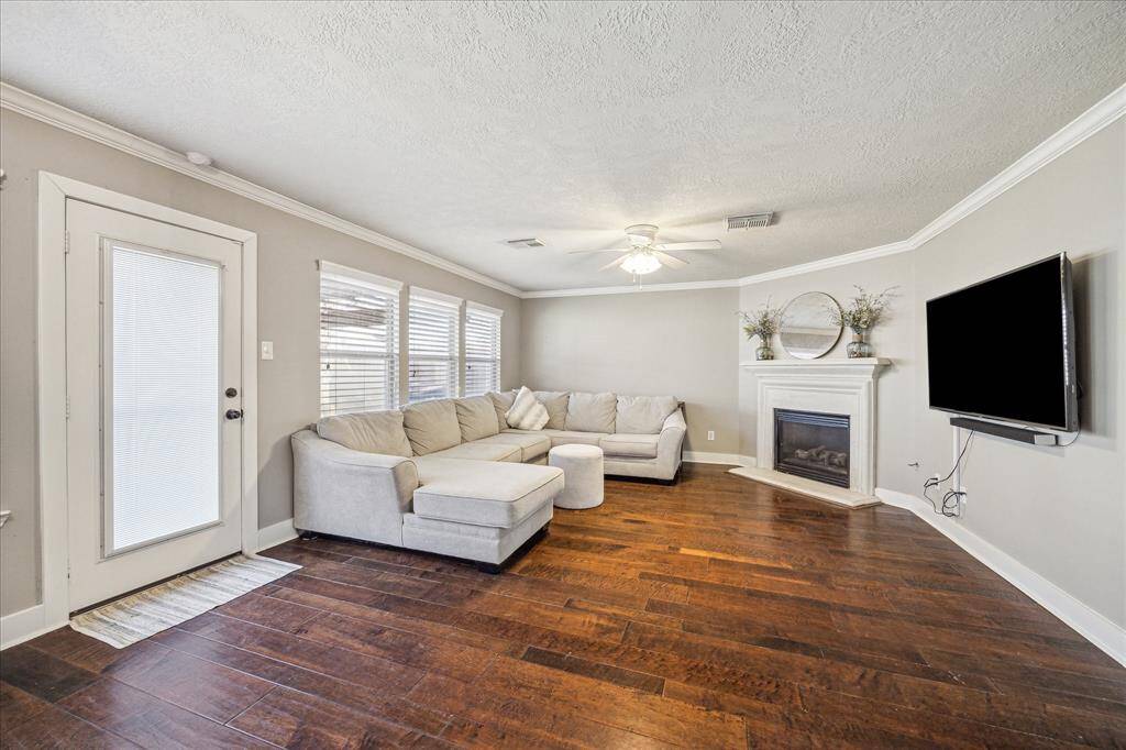 A beautiful fireplace anchors this living room, providing a cozy focal point and perfect ambiance for any occasion. Whether you're entertaining or relaxing, this space exudes warmth and charm.