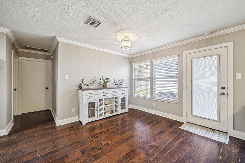 The open living space is complemented by a door opening up to the backyard, allowing natural light to fill the room and providing effortless access to your private outdoor oasis.